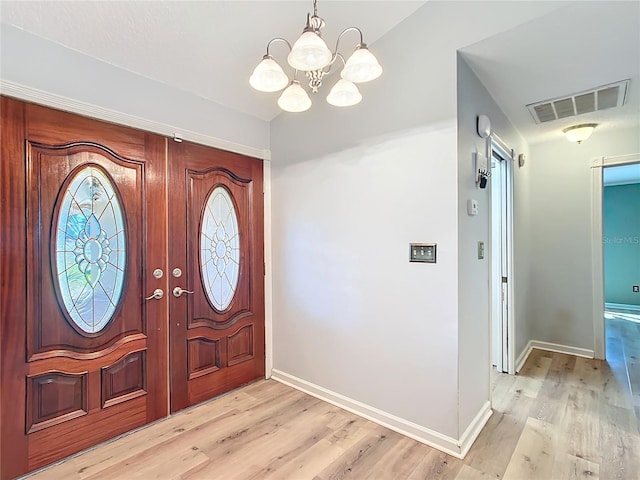 entryway featuring light hardwood / wood-style floors and an inviting chandelier