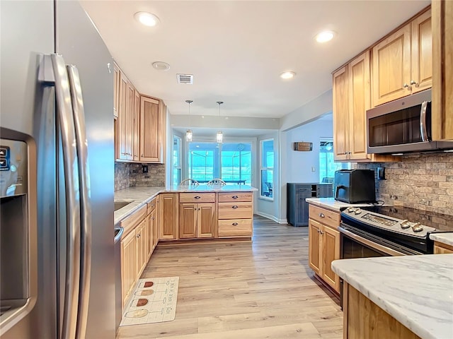 kitchen featuring light brown cabinetry, backsplash, stainless steel appliances, and hanging light fixtures