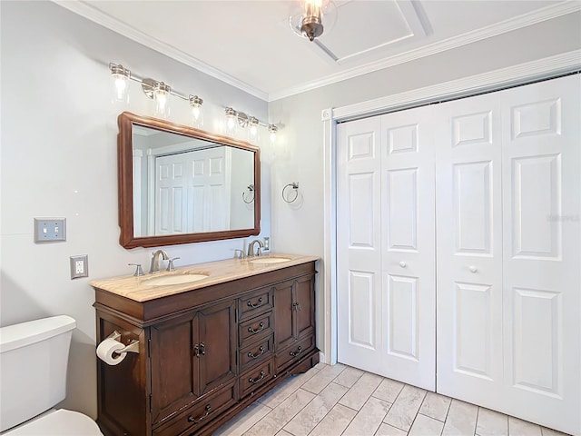 bathroom with toilet, vanity, and ornamental molding