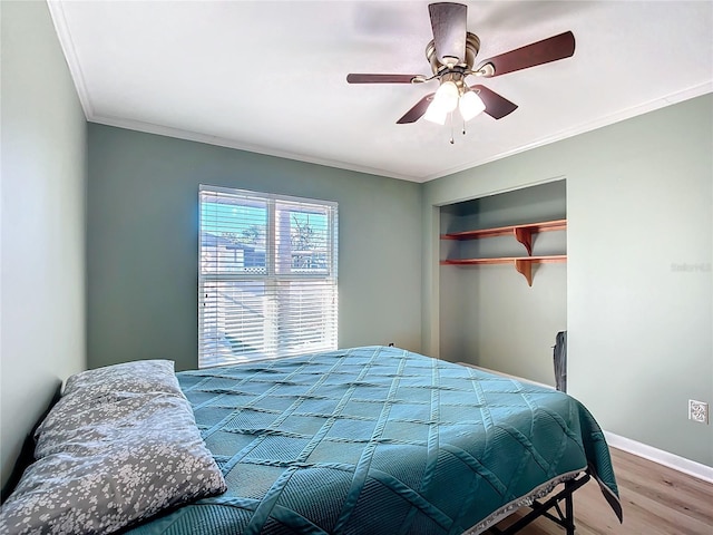 bedroom featuring crown molding, ceiling fan, a closet, and hardwood / wood-style floors