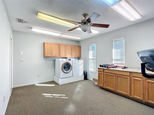 laundry area with ceiling fan, washer and clothes dryer, cabinets, and a textured ceiling