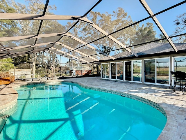 view of swimming pool with a patio area and a lanai