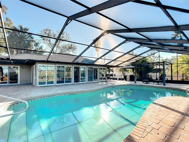 view of pool with glass enclosure and a patio area