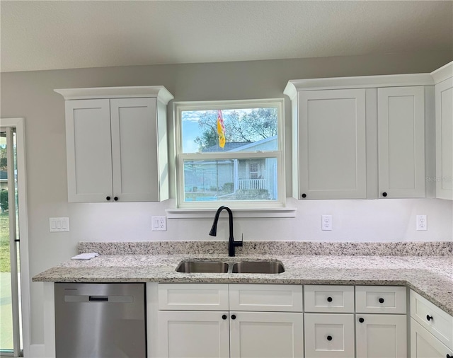 kitchen featuring white cabinets, dishwasher, sink, and light stone counters