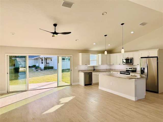 kitchen with white cabinetry, ceiling fan, appliances with stainless steel finishes, pendant lighting, and a center island