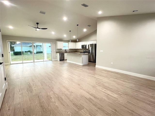 kitchen with decorative light fixtures, ceiling fan, a kitchen island, stainless steel appliances, and white cabinets