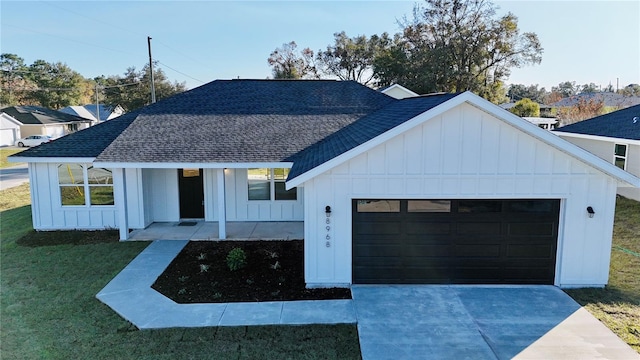 modern farmhouse featuring a porch, a garage, and a front lawn