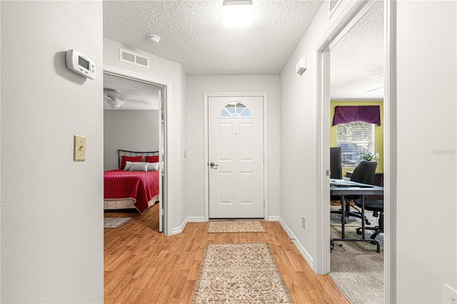 entryway featuring light hardwood / wood-style floors and a textured ceiling