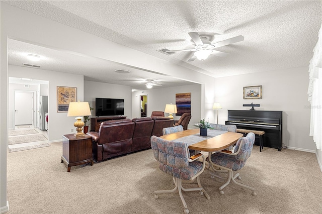 carpeted dining space with a textured ceiling and ceiling fan