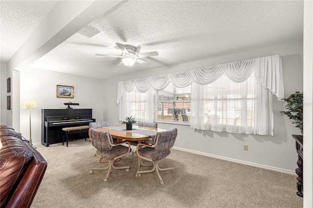 dining space with carpet flooring, a healthy amount of sunlight, and a textured ceiling