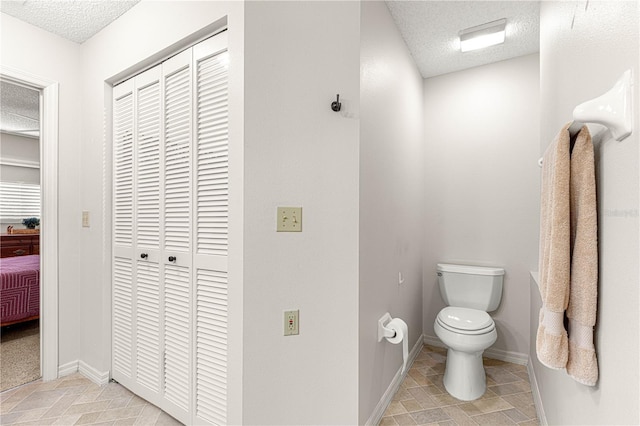 bathroom featuring a textured ceiling and toilet