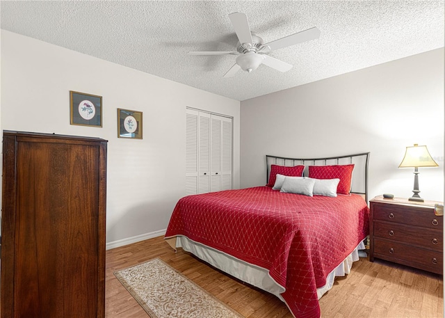 bedroom featuring ceiling fan, light hardwood / wood-style floors, a textured ceiling, and a closet