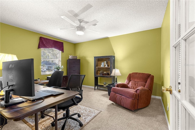 carpeted home office with ceiling fan and a textured ceiling