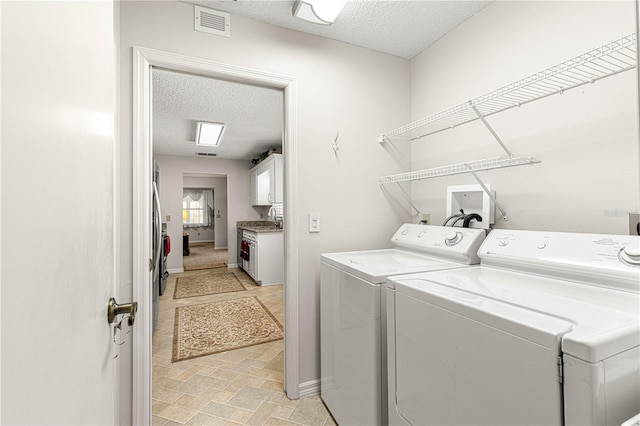 laundry area featuring washer and clothes dryer and a textured ceiling