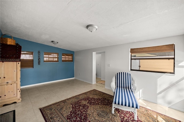 sitting room featuring a textured ceiling and lofted ceiling