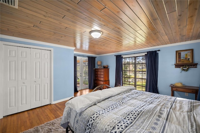 bedroom featuring multiple windows, ornamental molding, wood ceiling, and hardwood / wood-style flooring