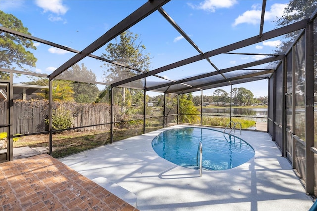 view of pool featuring glass enclosure, a water view, and a patio