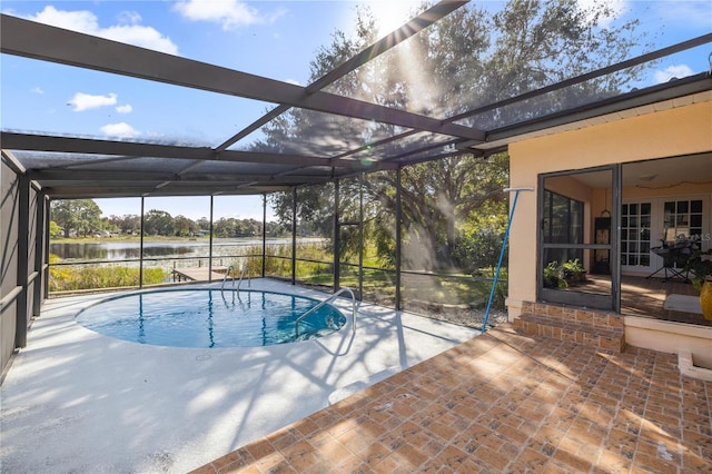 view of swimming pool with a patio, a water view, and a lanai