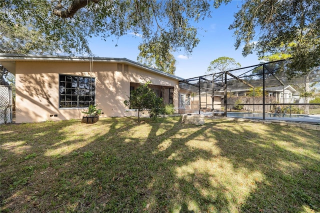 rear view of property with a fenced in pool, glass enclosure, and a lawn