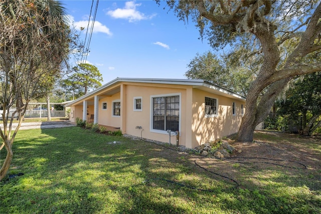 view of side of home with a carport and a yard