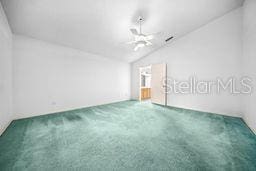 carpeted empty room featuring vaulted ceiling