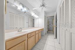 bathroom with tile patterned flooring, vanity, and ceiling fan