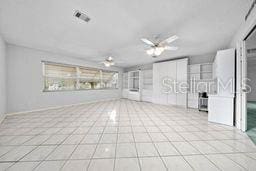 unfurnished living room with ceiling fan and light tile patterned flooring