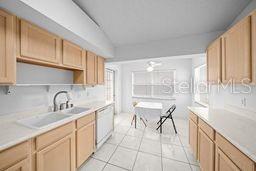 kitchen featuring dishwasher, light tile patterned floors, and light brown cabinets