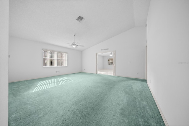 spare room featuring vaulted ceiling, carpet, visible vents, and ceiling fan