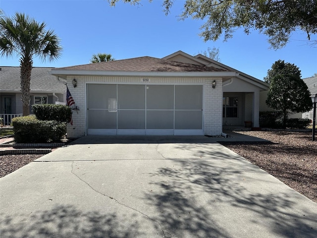 view of front of home featuring a garage, brick siding, and concrete driveway