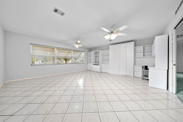 unfurnished living room featuring light tile patterned flooring, baseboards, visible vents, and a textured ceiling