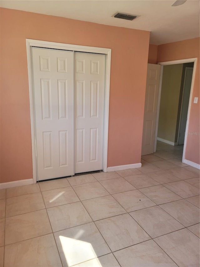 unfurnished bedroom with a closet and light tile patterned flooring