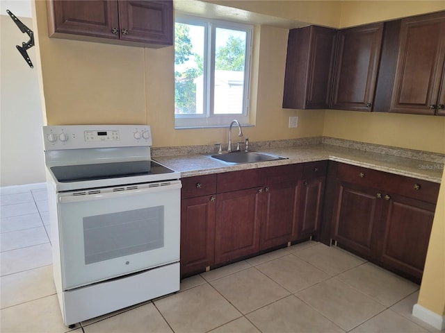 kitchen featuring light tile patterned floors, sink, and electric stove