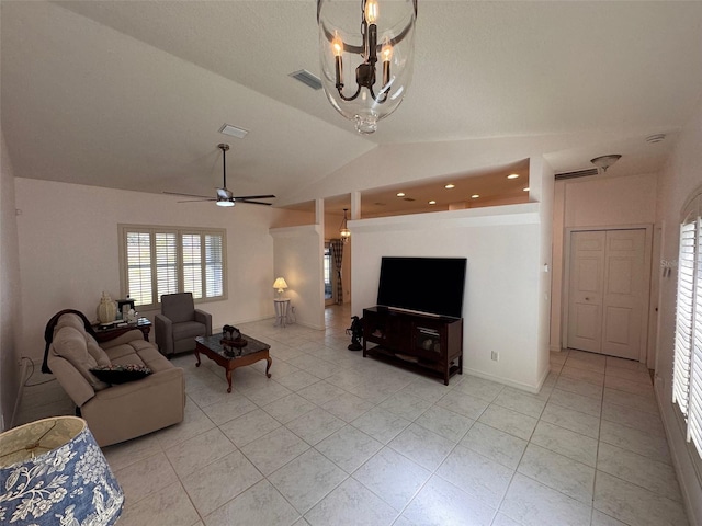 tiled living room with ceiling fan with notable chandelier and vaulted ceiling