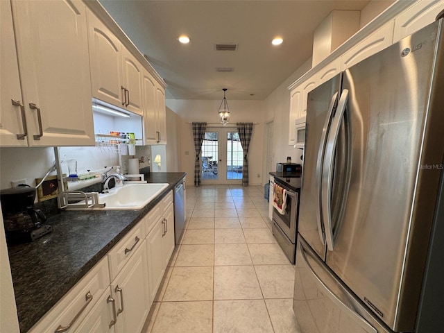 kitchen featuring light tile patterned floors, sink, decorative light fixtures, stainless steel appliances, and french doors