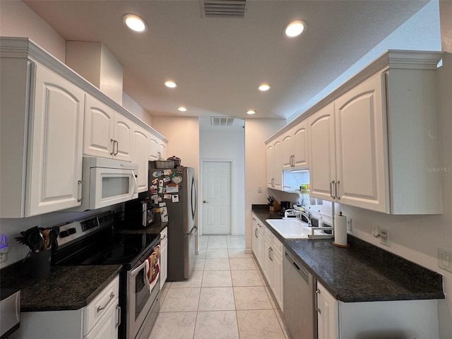 kitchen featuring white cabinets, appliances with stainless steel finishes, sink, and light tile patterned floors