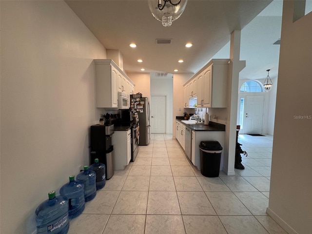 kitchen featuring an inviting chandelier, stainless steel appliances, light tile patterned floors, and sink