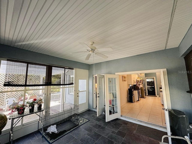 sunroom / solarium featuring french doors and ceiling fan