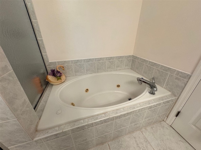 bathroom featuring tile patterned flooring and tiled tub