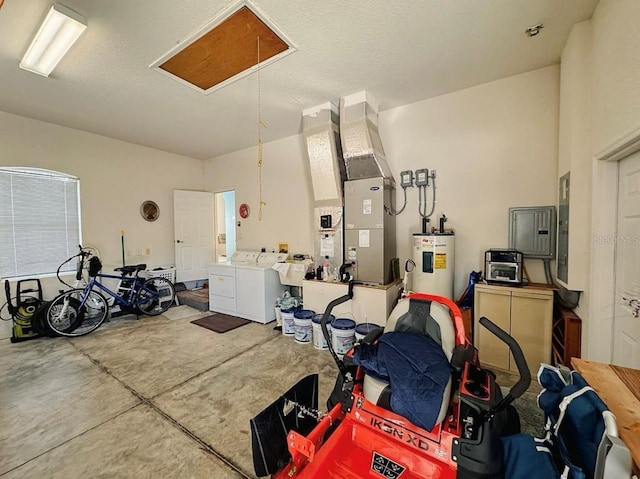 garage featuring heating unit, water heater, electric panel, and separate washer and dryer