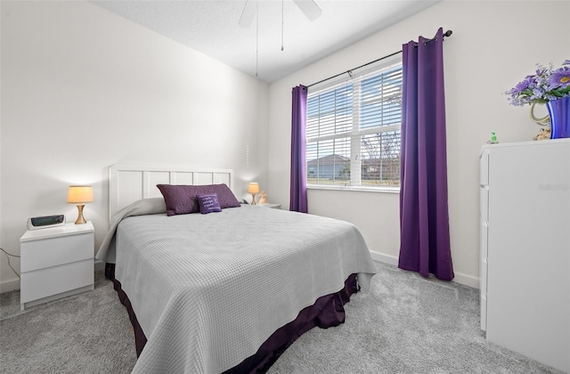 bedroom featuring ceiling fan, light carpet, and a textured ceiling