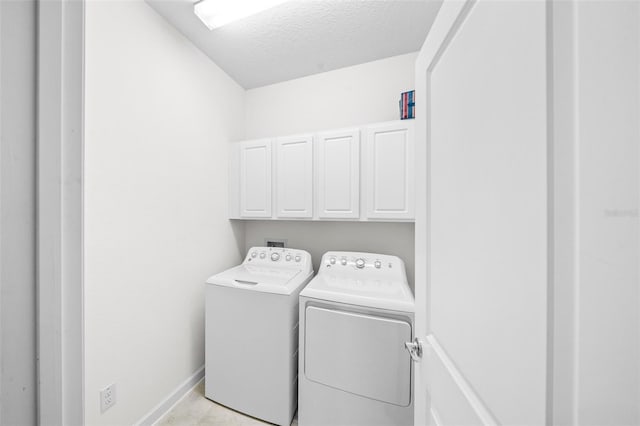 laundry room featuring cabinets, independent washer and dryer, and a textured ceiling