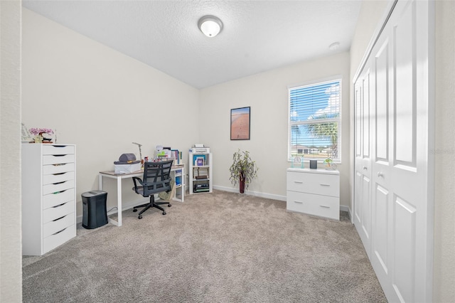 office area featuring light carpet and a textured ceiling