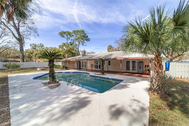 view of swimming pool with a patio area and french doors