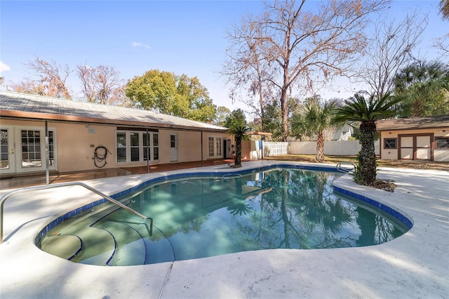 view of swimming pool featuring french doors and a patio