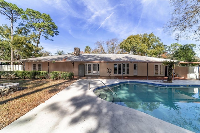 view of swimming pool featuring a patio and french doors