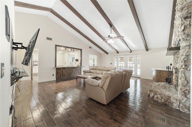 living room featuring beamed ceiling, high vaulted ceiling, and ceiling fan