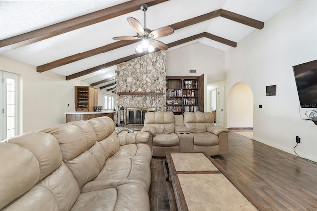 living room with a stone fireplace, ceiling fan, vaulted ceiling, and hardwood / wood-style flooring