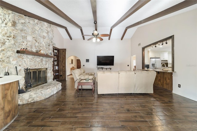 living room featuring ceiling fan, a fireplace, lofted ceiling with beams, and sink