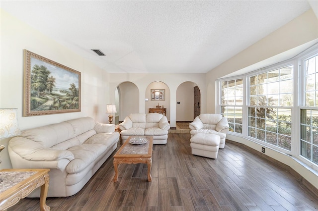 living room featuring dark hardwood / wood-style flooring, a healthy amount of sunlight, and a textured ceiling